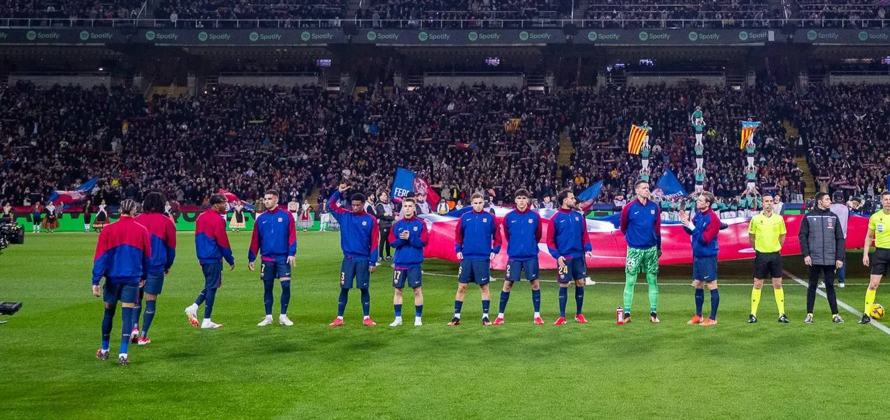 Jugadors del FC Barcelona amb pilars castellers al darrere durant l'homenatge DANA